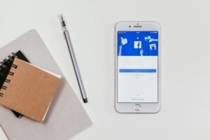 Minimalist workspace featuring a smartphone with social media login and notepad.